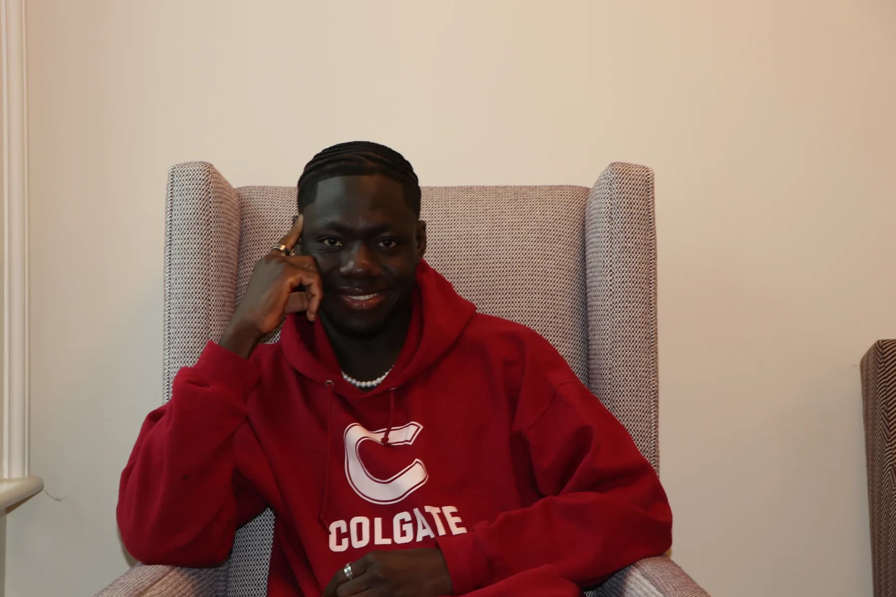 Bob Aboh seated in a Colgate University hoodie