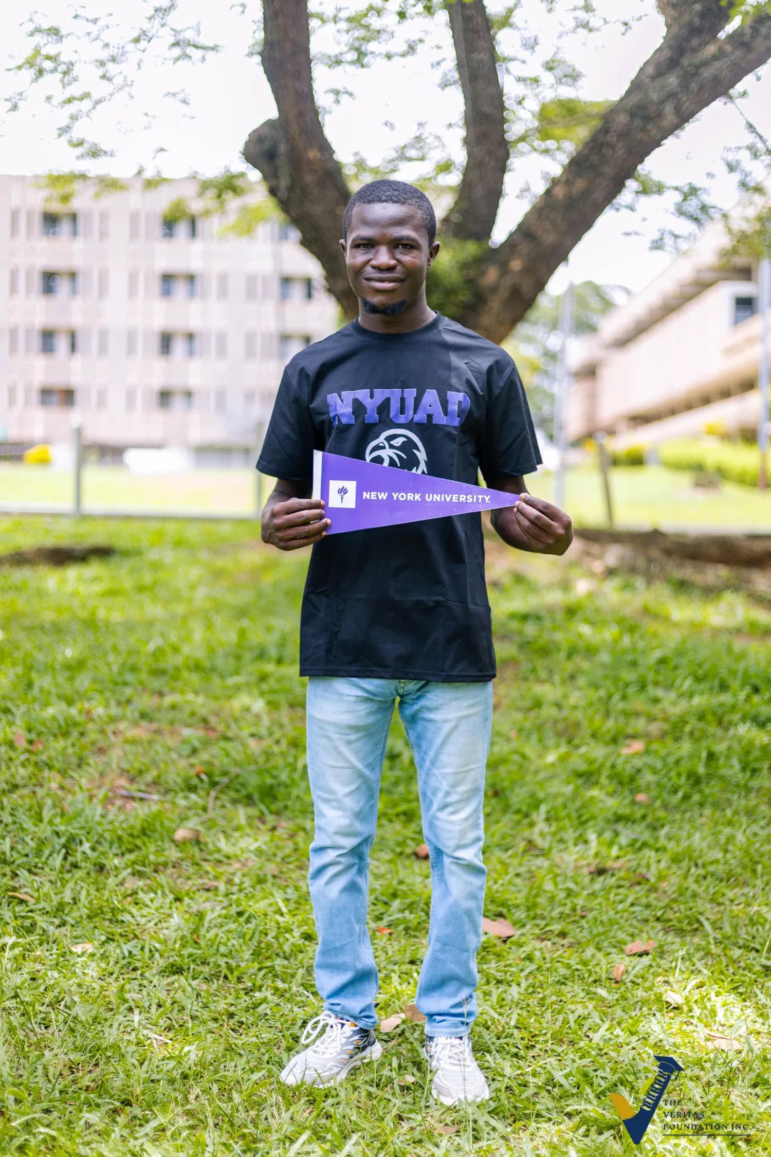 A Veritas scholar holding a New York University pennant