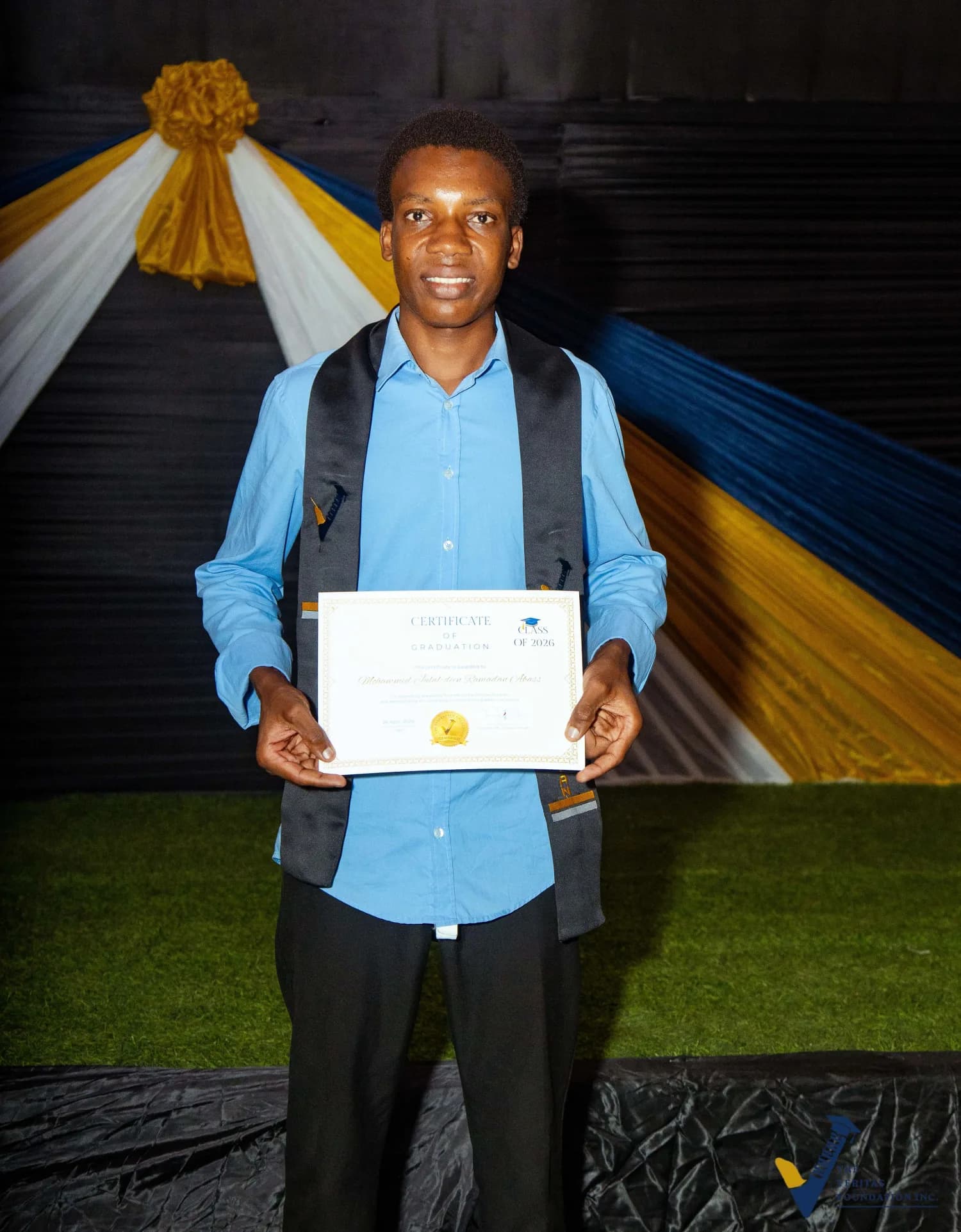 A Veritas scholar holding a certificate at matriculation