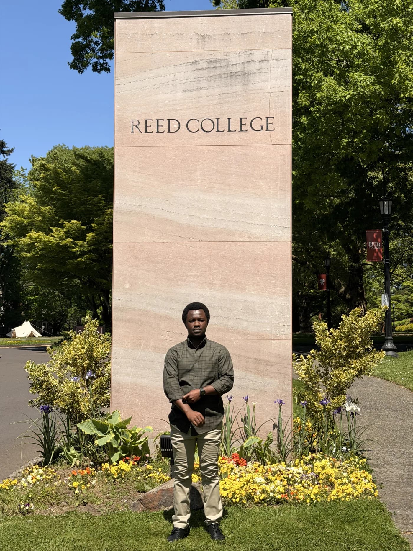 Foster Echia standing beside the Reed College sign